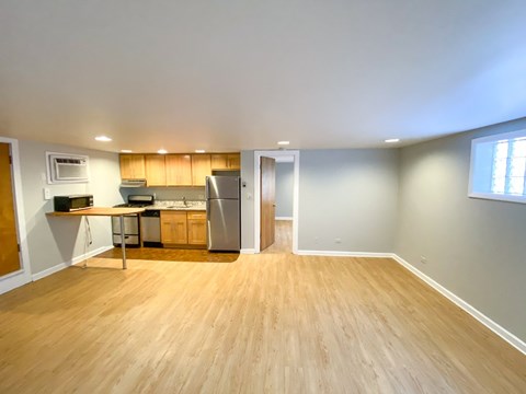 A kitchen with wooden floors and a refrigerator.