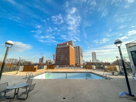 the pool on the rooftop of a building with the city in the background