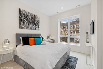 a bedroom with a large bed and two windows