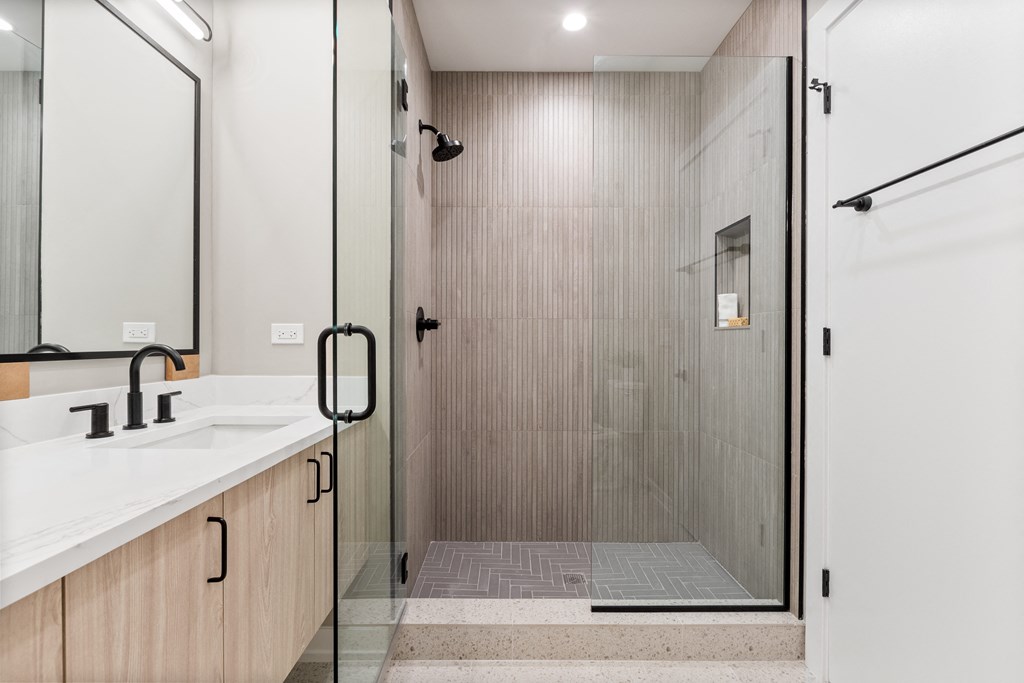 a bathroom with a shower and a sink and a mirror