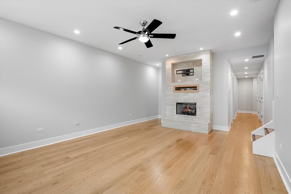 A room with a fireplace and a ceiling fan.