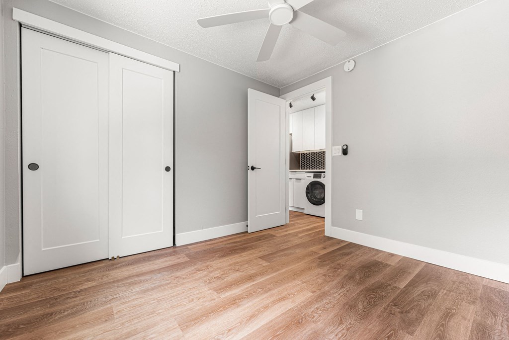a bedroom with two closets and a washer and dryer