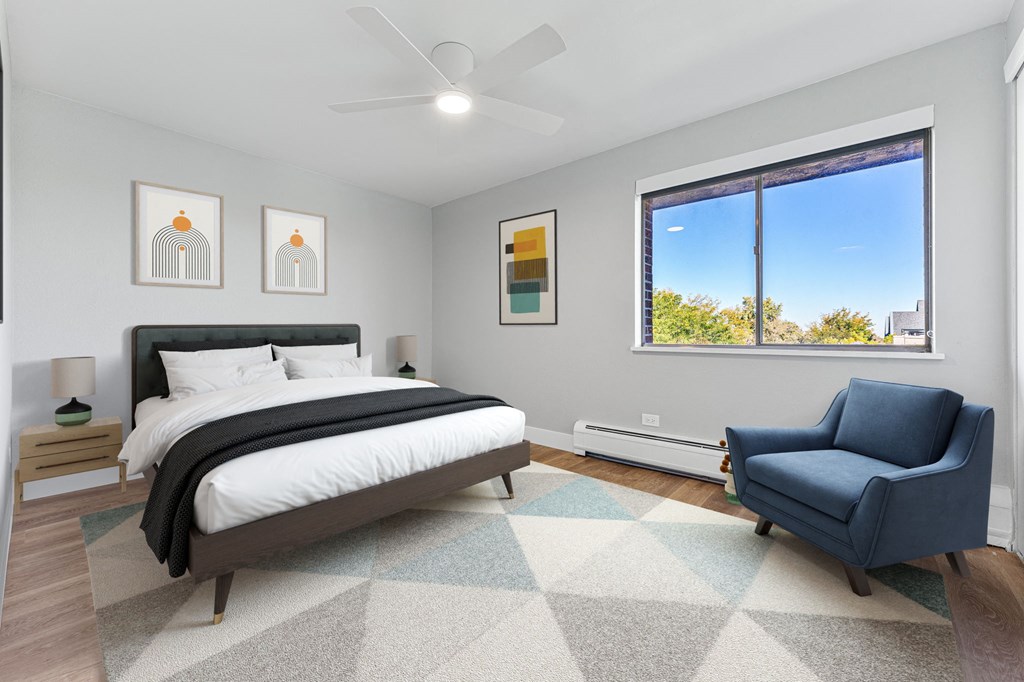 a bedroom with a bed and a chair and a window