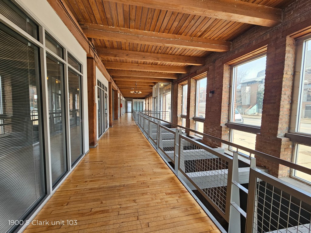a corridor in a building with wood floors and windows