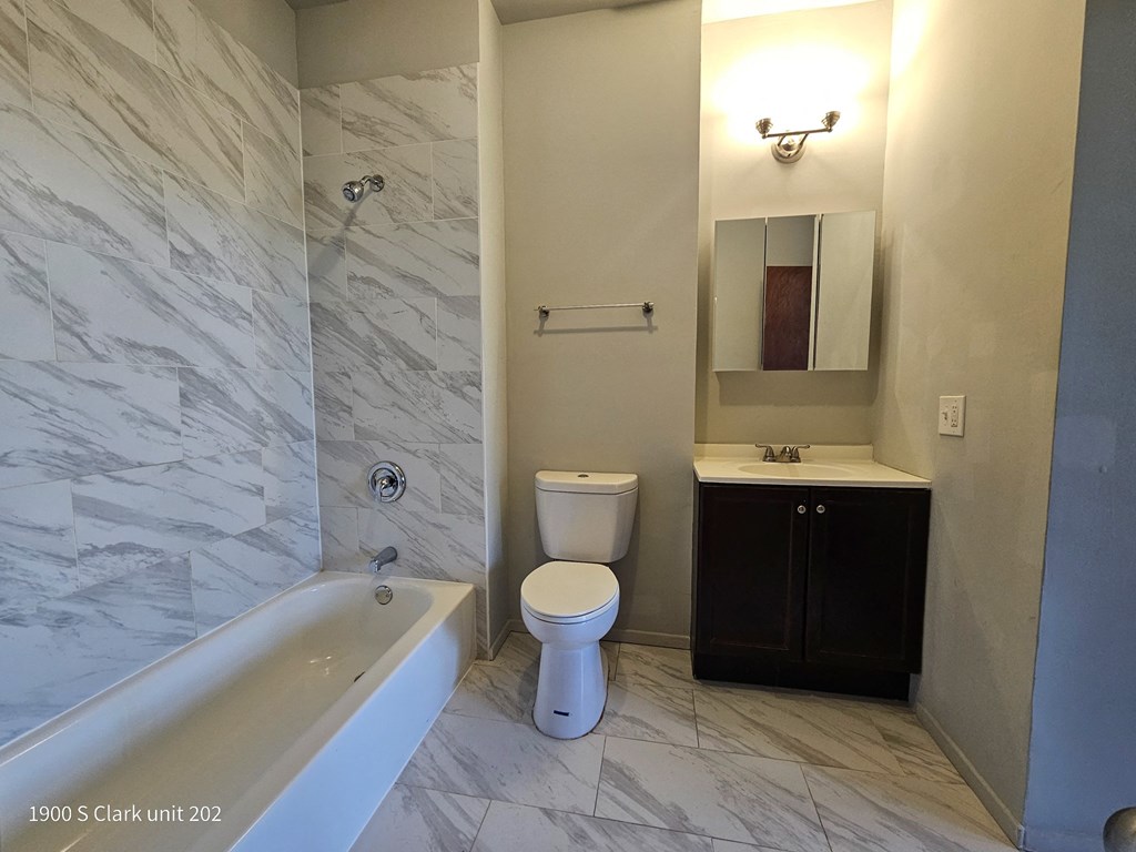 a bathroom with a toilet and a tub and a sink