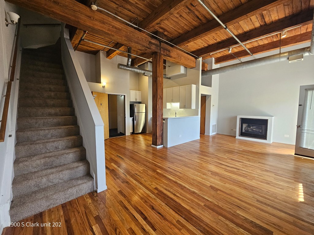 a view of a living room with wood floors and a staircase