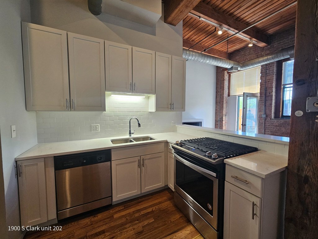 a kitchen with white cabinets and a stove and a sink