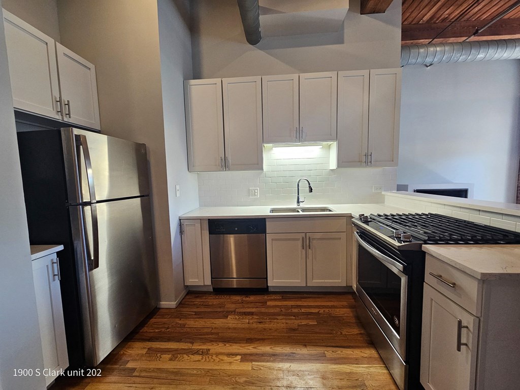 a small kitchen with white cabinets and stainless steel appliances