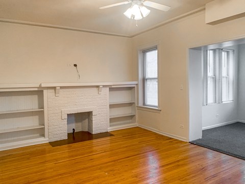 A room with a fireplace and wooden floors.
