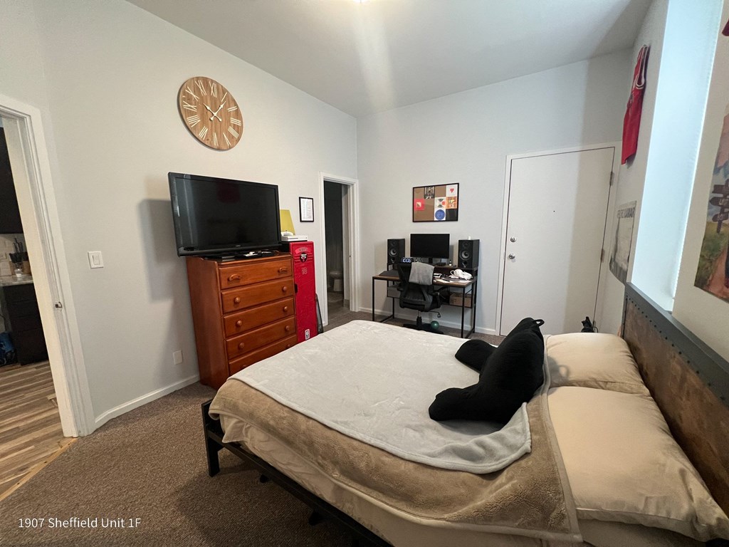 a bedroom with a bed and a tv