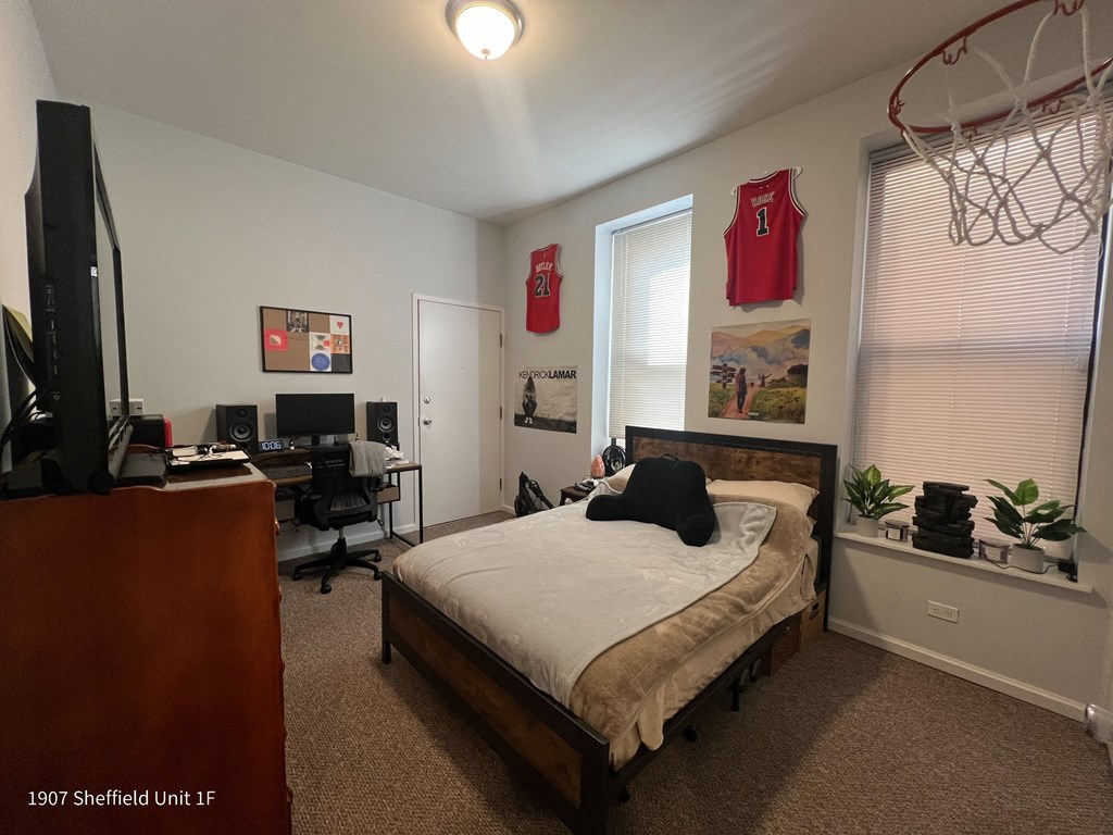 a bedroom with a bed and a desk and a window