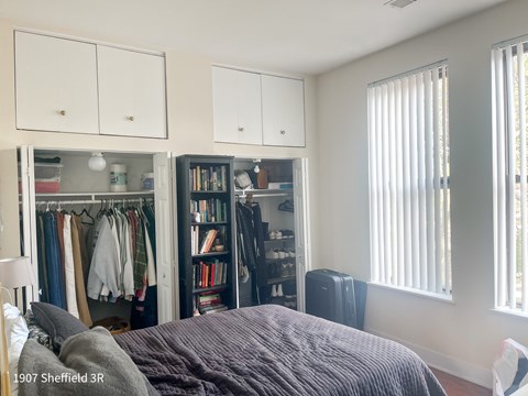 A bedroom with a bed, a wardrobe, and a bookshelf.