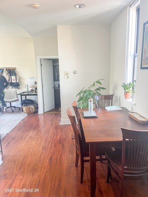 A dining room with a wooden table and chairs.