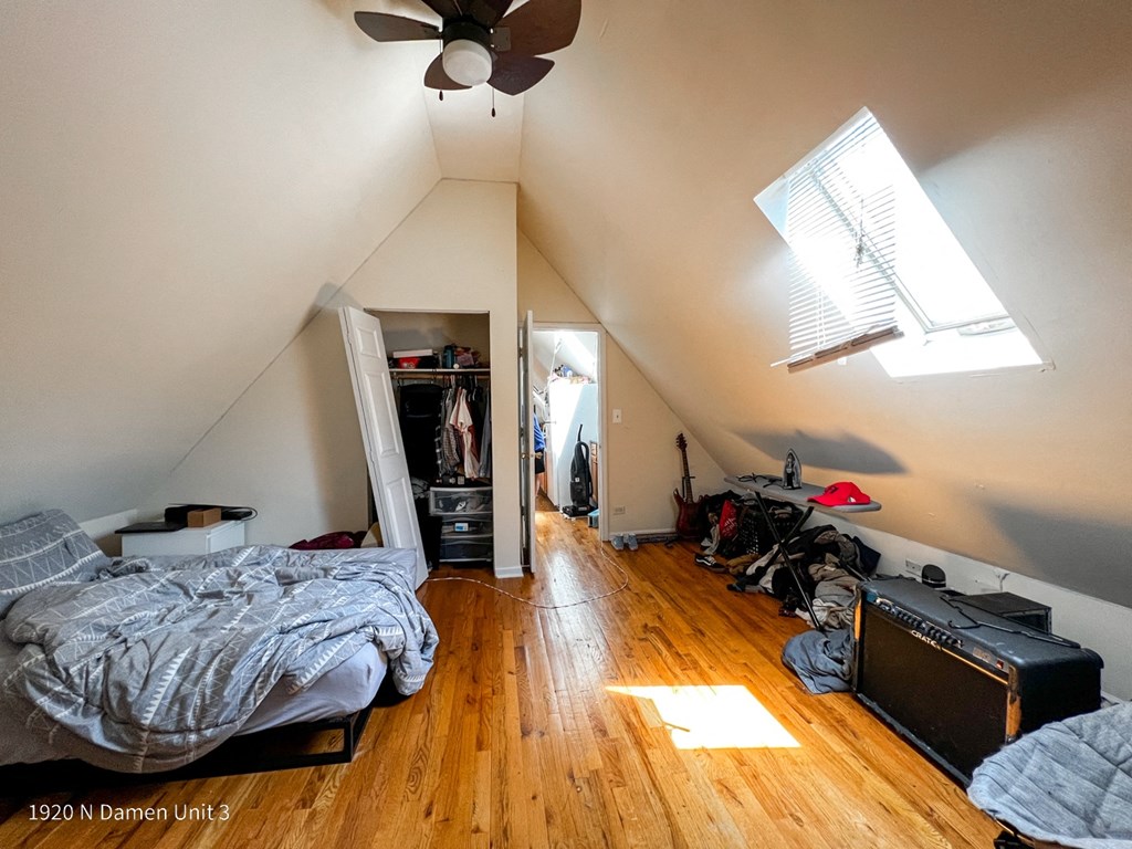 a bedroom with a bed and a ceiling fan and a closet