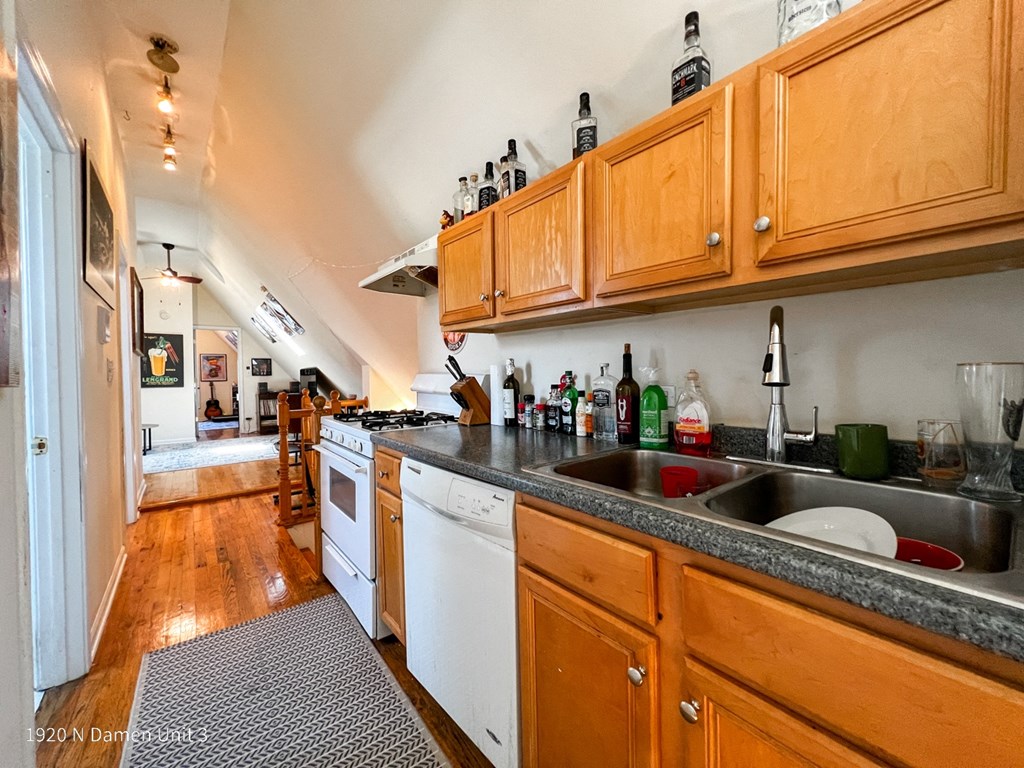 a kitchen with a sink and a dishwasher and wooden cabinets