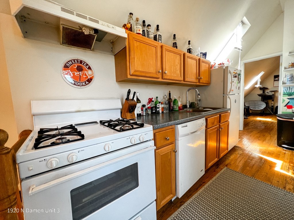 a kitchen with white appliances and wooden cabinets