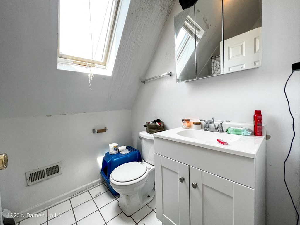 a bathroom with a toilet and a sink and a window