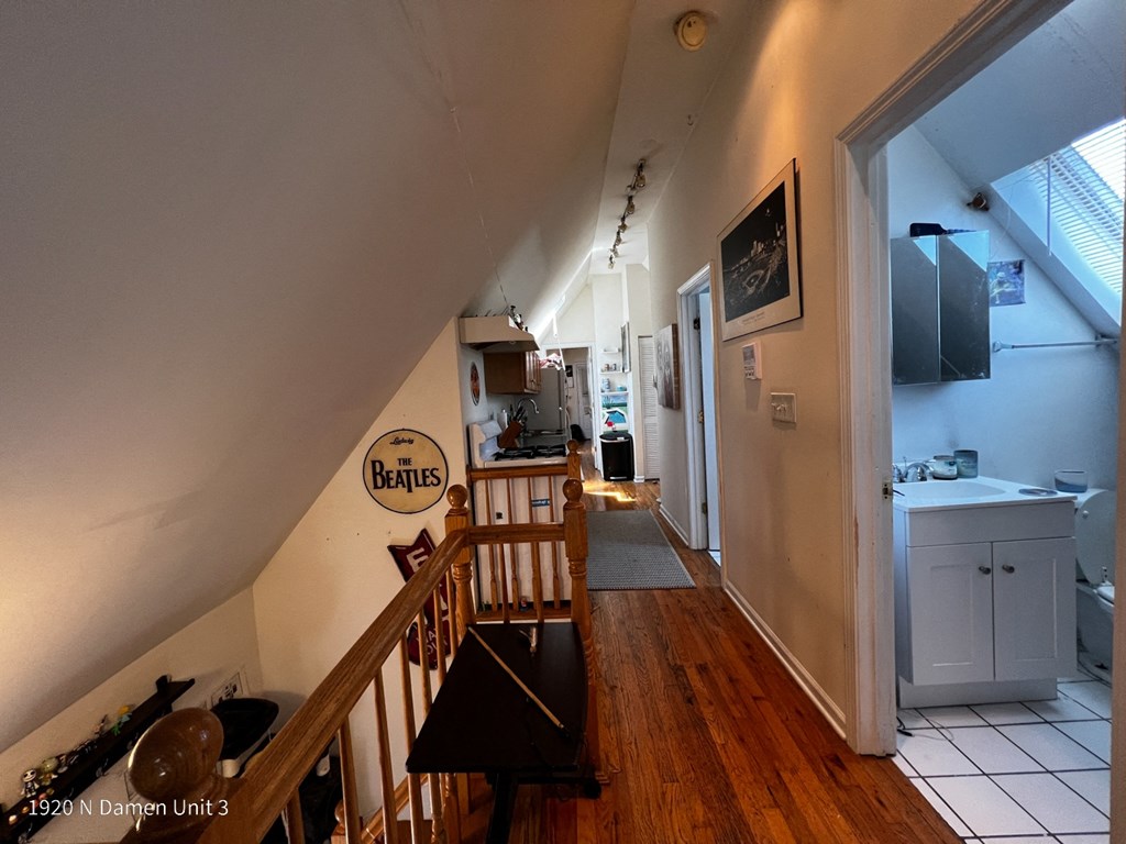 the view from the top of the stairs looking into the kitchen and the living room