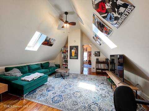 a living room with a green couch and a blue and white rug