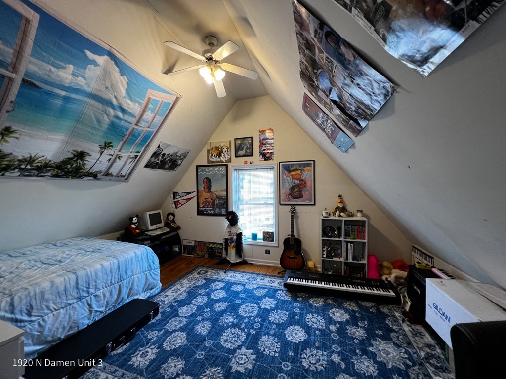 a bedroom with a bed and a ceiling fan and a blue rug