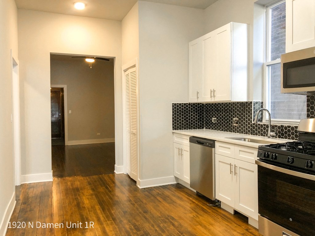 a kitchen with white cabinets and a stove and a sink