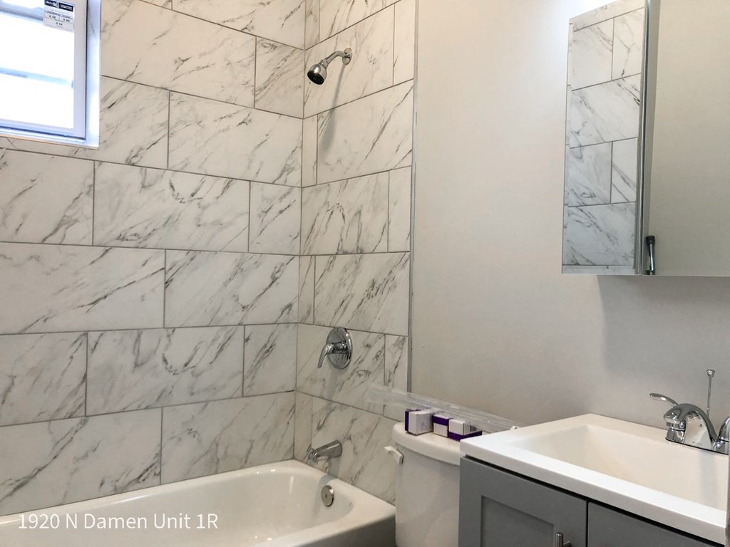 a bathroom with a tub and a sink and a mirror