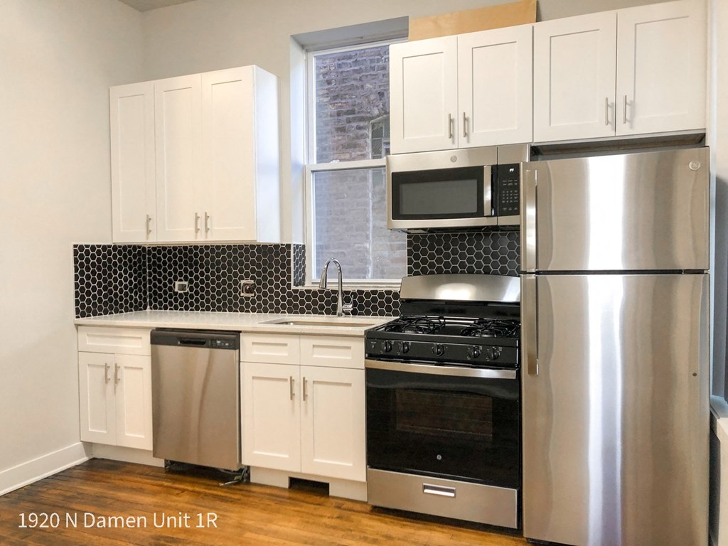 a kitchen with stainless steel appliances and white cabinets