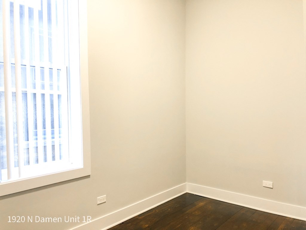 a corner of a room with white walls and a window