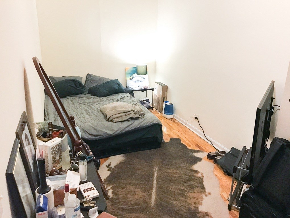 a bedroom with a bed and a rug on the floor