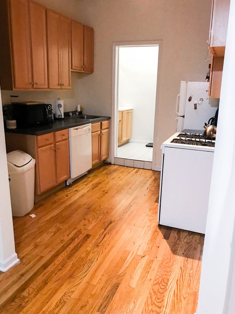 a kitchen with wooden floors and a white stove and refrigerator