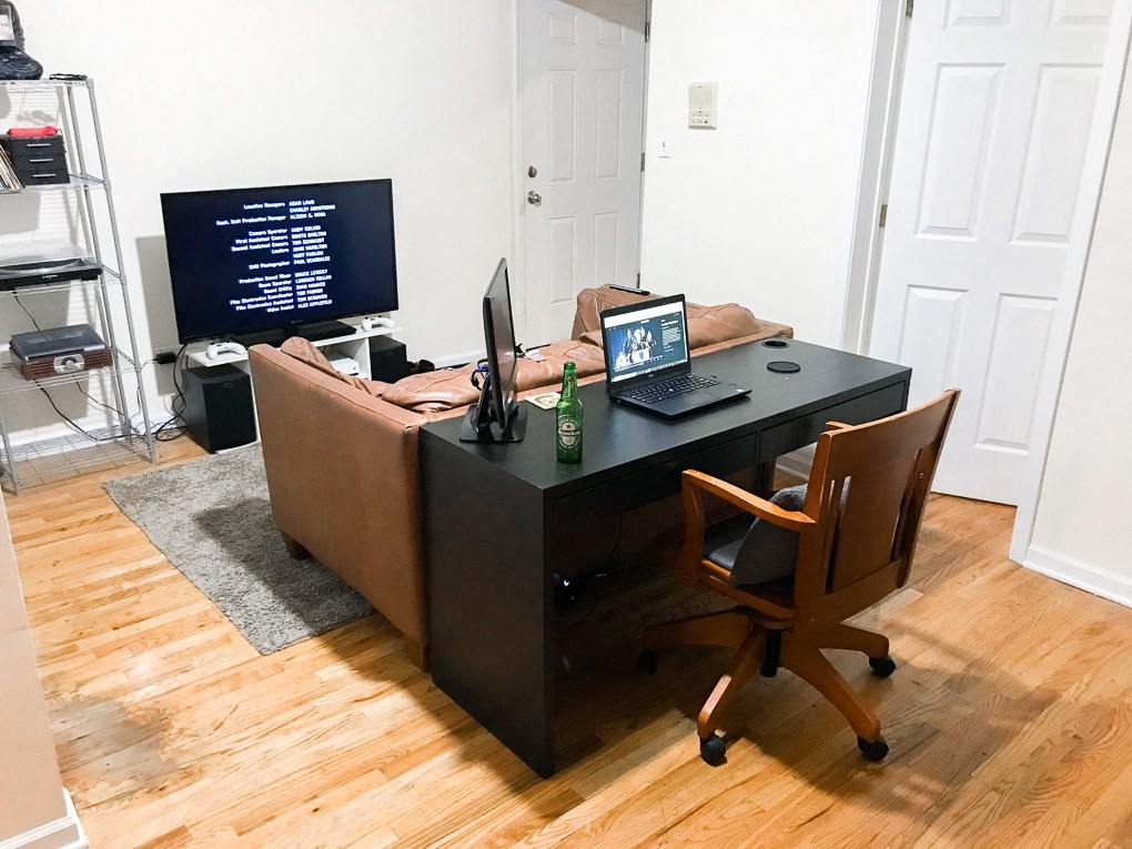 a living room with a couch and a desk with a computer