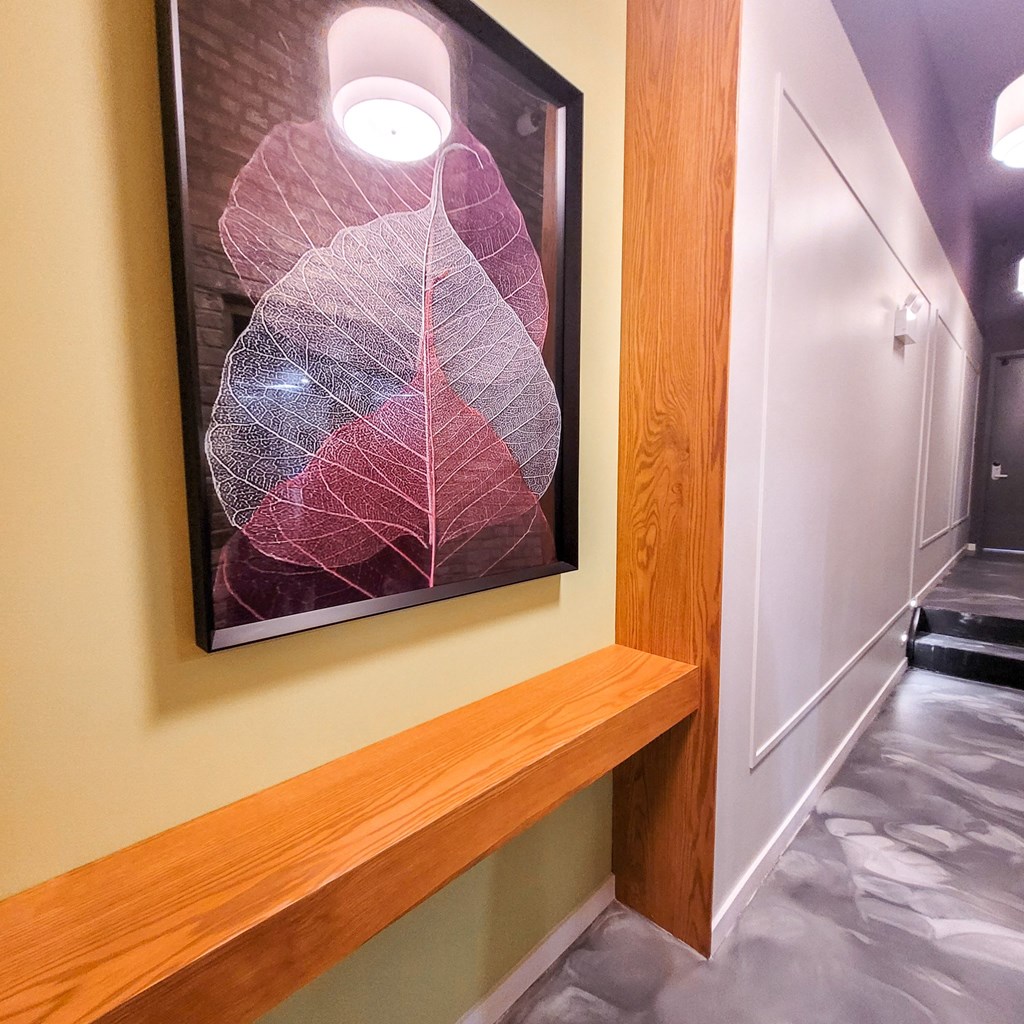 a hallway with a painting of leaves on the wall