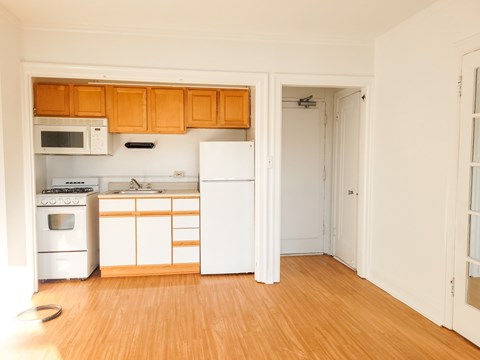 A kitchen with white appliances and wooden cabinets.