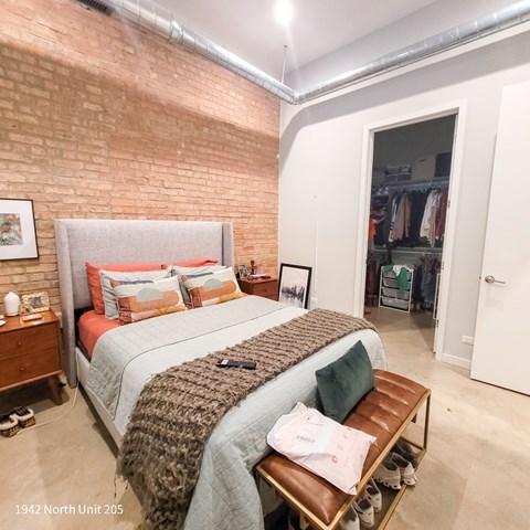A bedroom with a large bed and a brick wall.