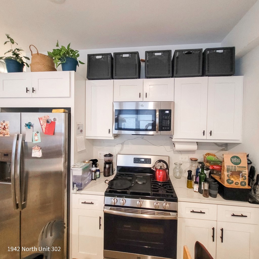 a white kitchen with black appliances and white cabinets