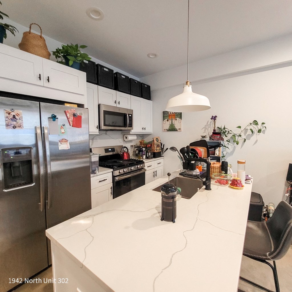 a kitchen with a white counter top and stainless steel appliances