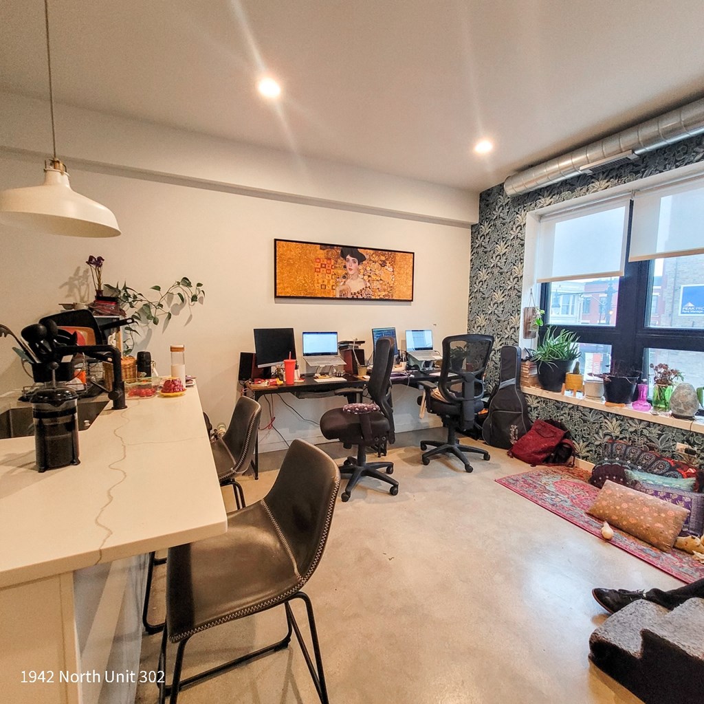 a home office with desks and chairs and a window