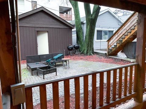 A backyard with a wooden deck and a tree.