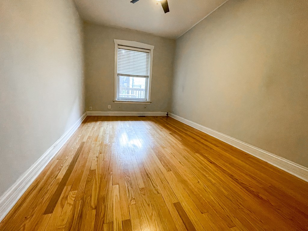 A room with wooden flooring and a window.