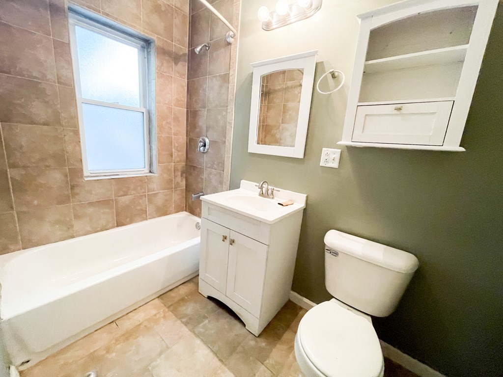 A white toilet sits next to a white sink in a bathroom.