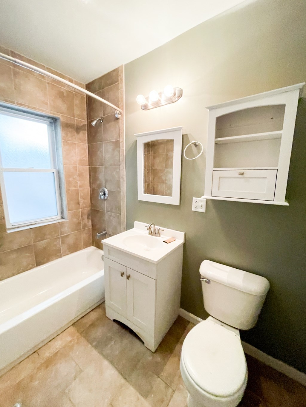 A white toilet sits next to a bathtub in a bathroom.