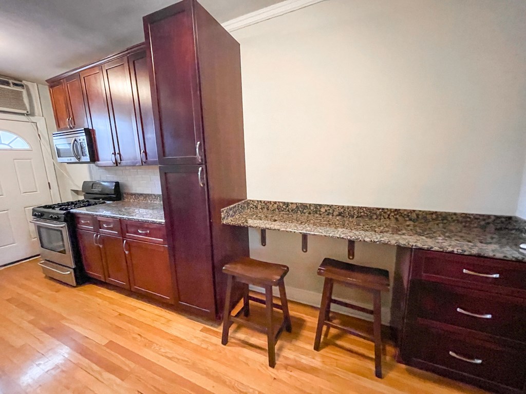 A kitchen with wooden cabinets and a granite countertop.