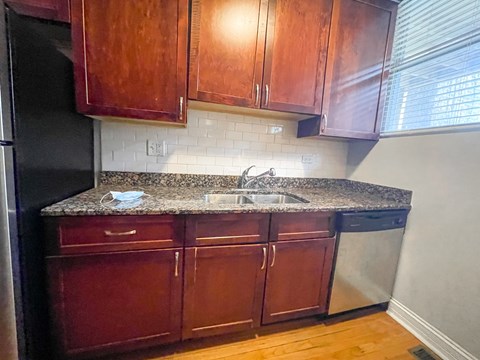 A kitchen with wooden cabinets and a granite countertop.