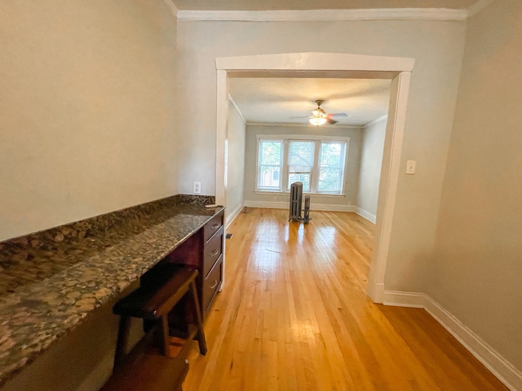 A long hallway with a window and a fan.