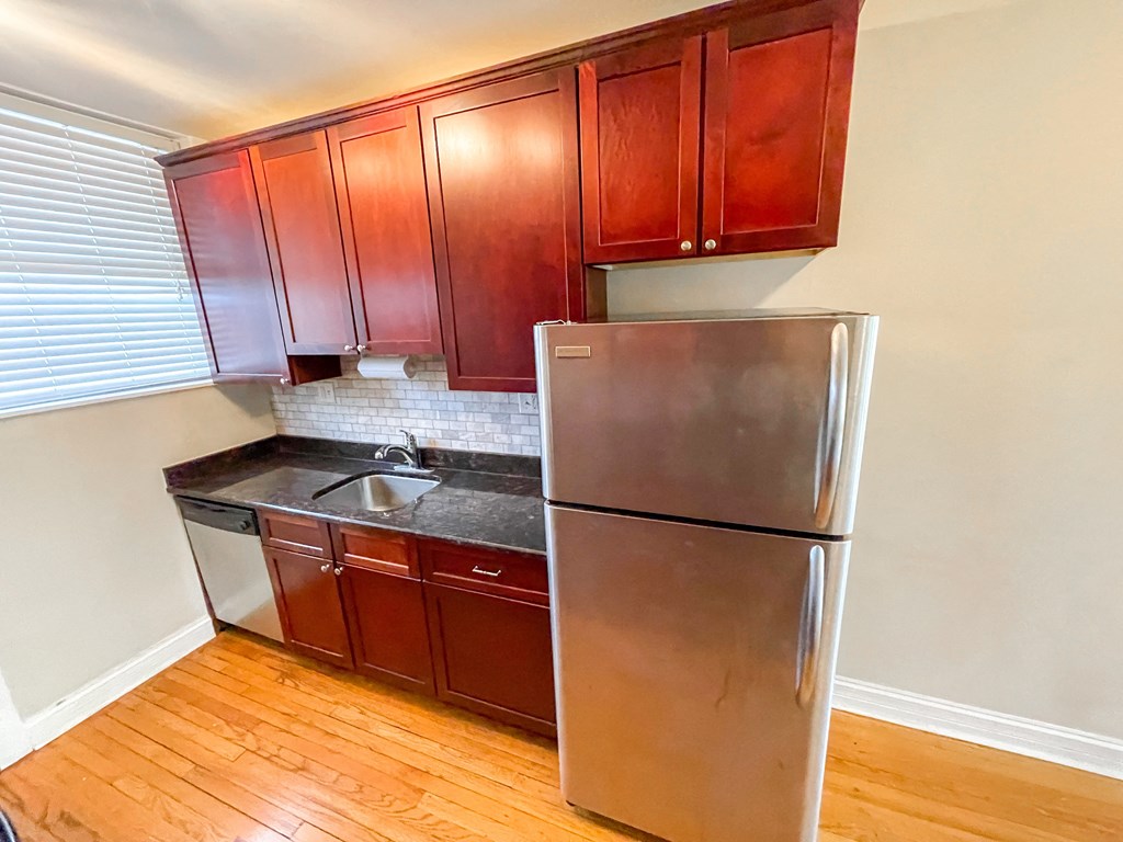 a kitchen with a stainless steel refrigerator and wooden cabinets