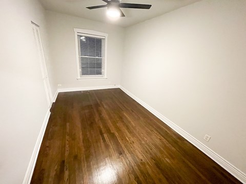 A room with a wooden floor and a ceiling fan.