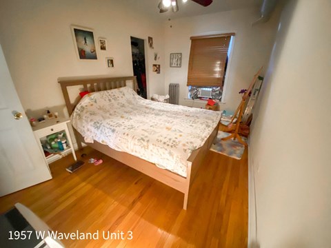 a bedroom with a bed and a wooden floor