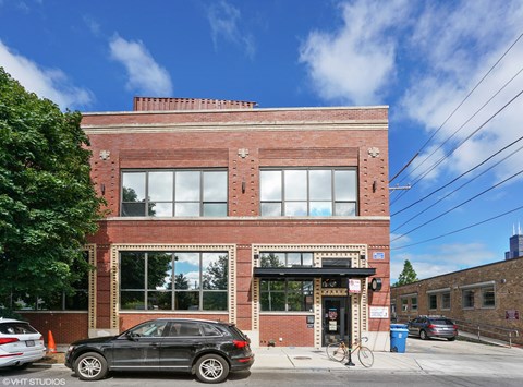 a brick building with a black car parked in front of it