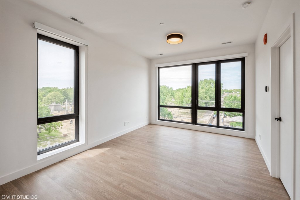 ceiling to floor windows in living space with hardwood flooring