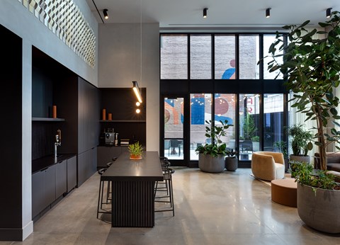 A modern kitchen with a black countertop and bar stools.